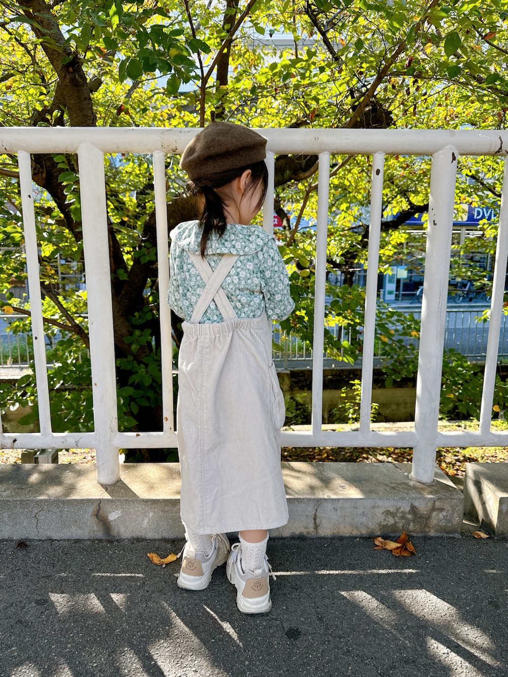 ホワイト系のジャンパースカート、グリーン系のTシャツ/カットソーを着用したキッズの秋コーディネートの3枚目の写真