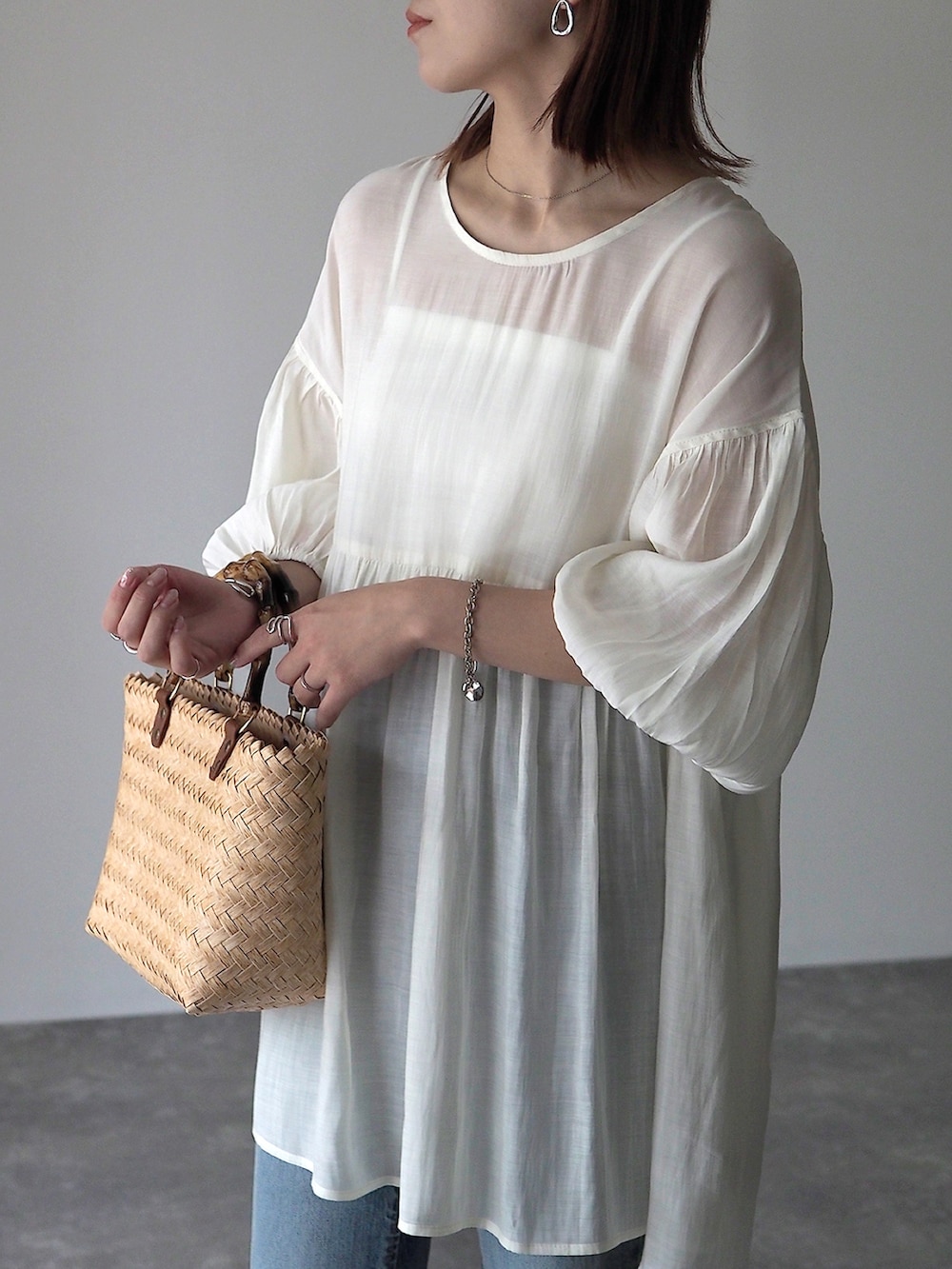 ホワイト系のシャツ/ブラウス、ベージュ系のかごバッグを着用したレディースの夏コーディネートの2枚目の写真