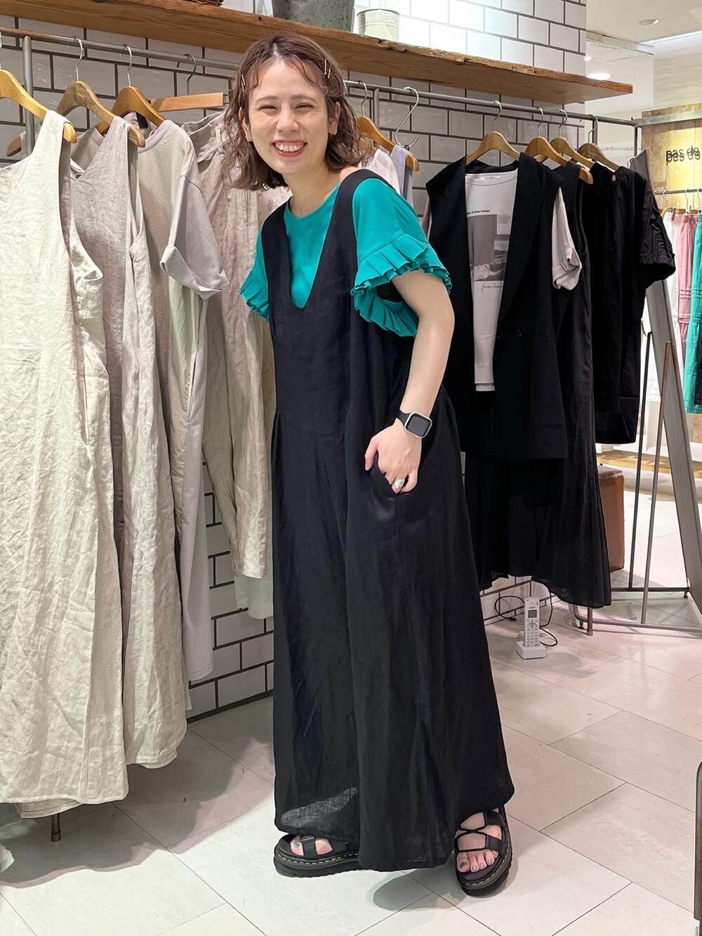 ブラック系のサロペット/オーバーオール、ブラック系のTシャツ/カットソー、ブラック系のサンダルを着用したレディースの夏コーディネートの2枚目の写真