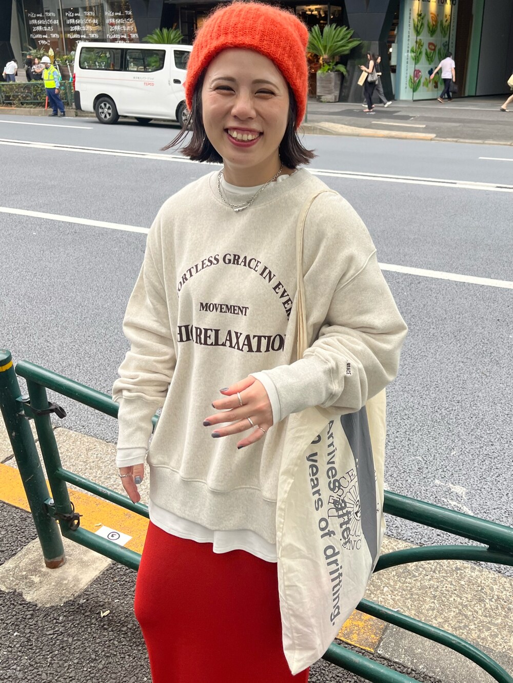 ベージュ系のスウェット、ホワイト系のTシャツ/カットソー、オレンジ系のスカートを着用したレディースの秋コーディネートの2枚目の写真