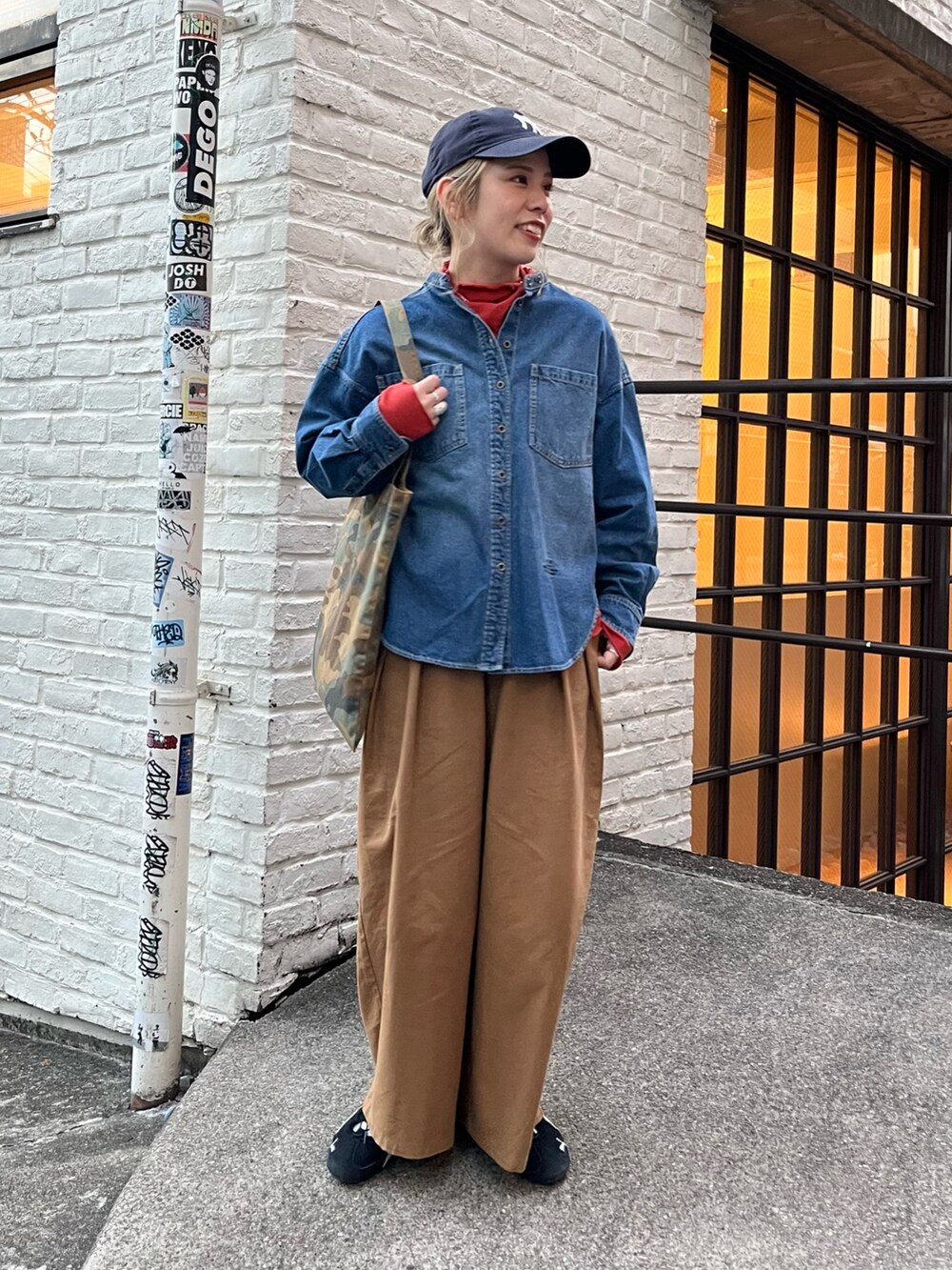 ブラック系のダウンジャケット/コート、ブルー系のシャツ/ブラウス、オレンジ系のTシャツ/カットソーを着用したレディースの秋コーディネートの2枚目の写真