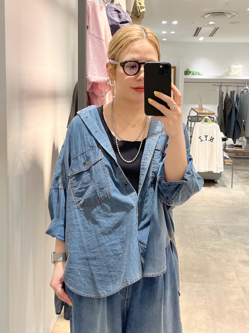 ブルー系のデニムパンツ、ブルー系のシャツ/ブラウス、ブラック系のタンクトップを着用したレディースの春コーディネートの2枚目の写真