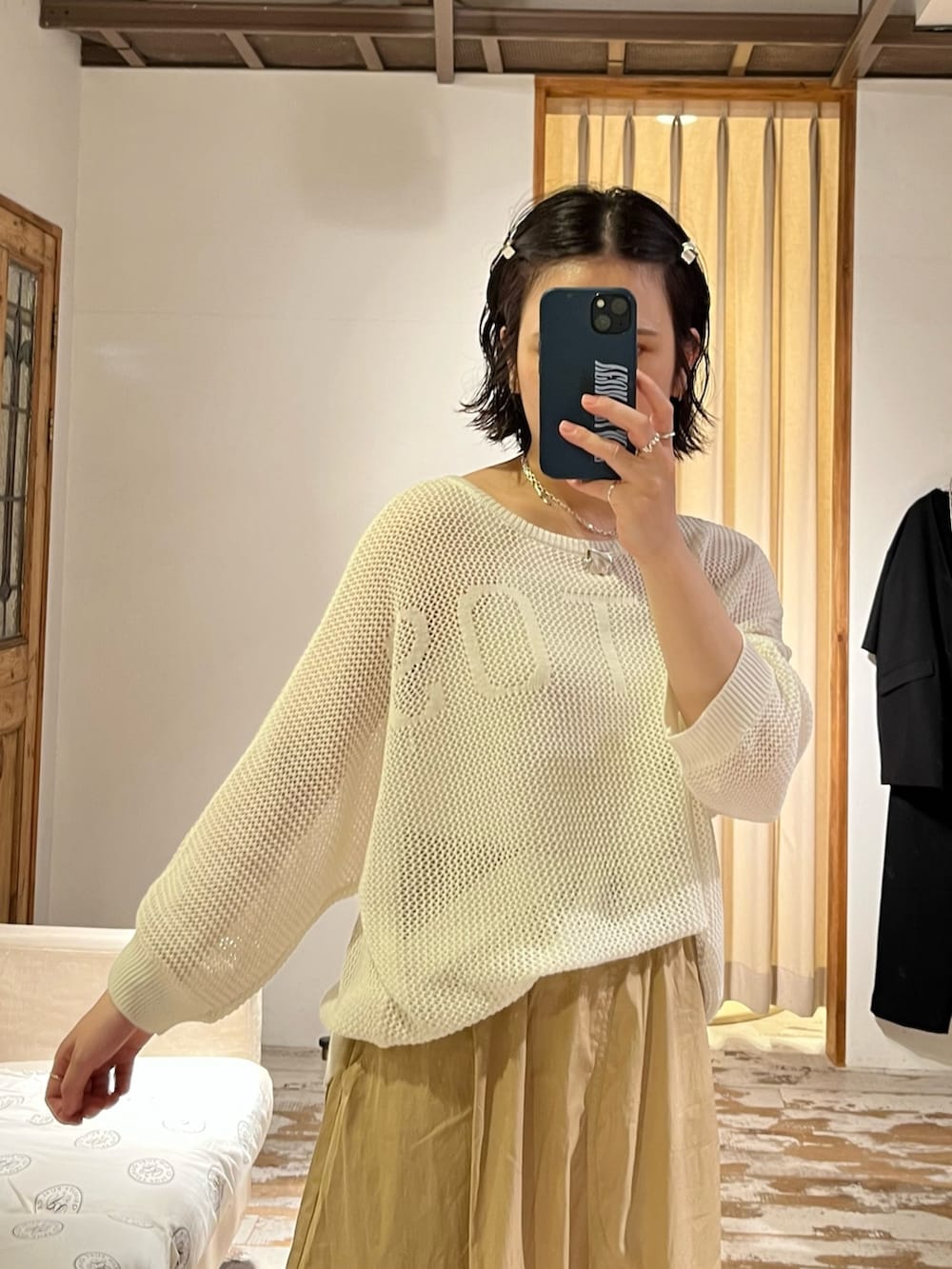 ベージュ系のスカート、ホワイト系のカーディガン/ボレロを着用したレディースの夏コーディネートの2枚目の写真