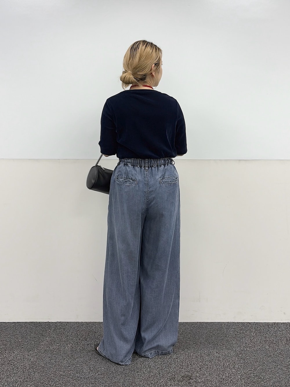 ブルー系のデニムパンツ、ブラック系のハンドバッグ、ブルー系のTシャツ/カットソーを着用したレディースの夏コーディネートの2枚目の写真