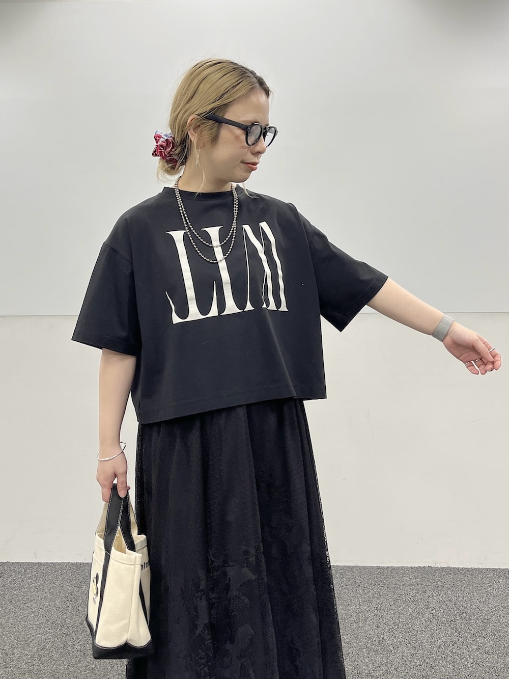 ブラック系のTシャツ/カットソー、ブラック系のスカート、ホワイト系のスニーカーを着用したレディースの冬コーディネートの3枚目の写真