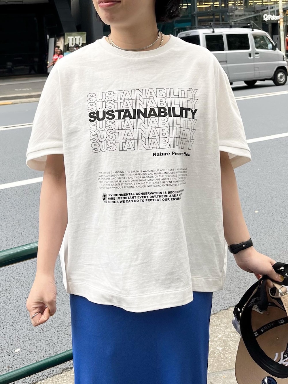 ホワイト系のTシャツ/カットソー、ブルー系のスカート、シルバー系のスニーカーを着用したレディースの春コーディネートの2枚目の写真
