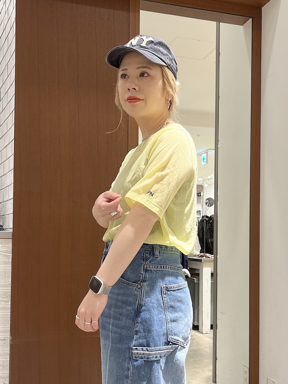 ブルー系のデニムパンツ、イエロー系のTシャツ/カットソー、ブラック系のサンダルを着用したレディースの春コーディネートの3枚目の写真