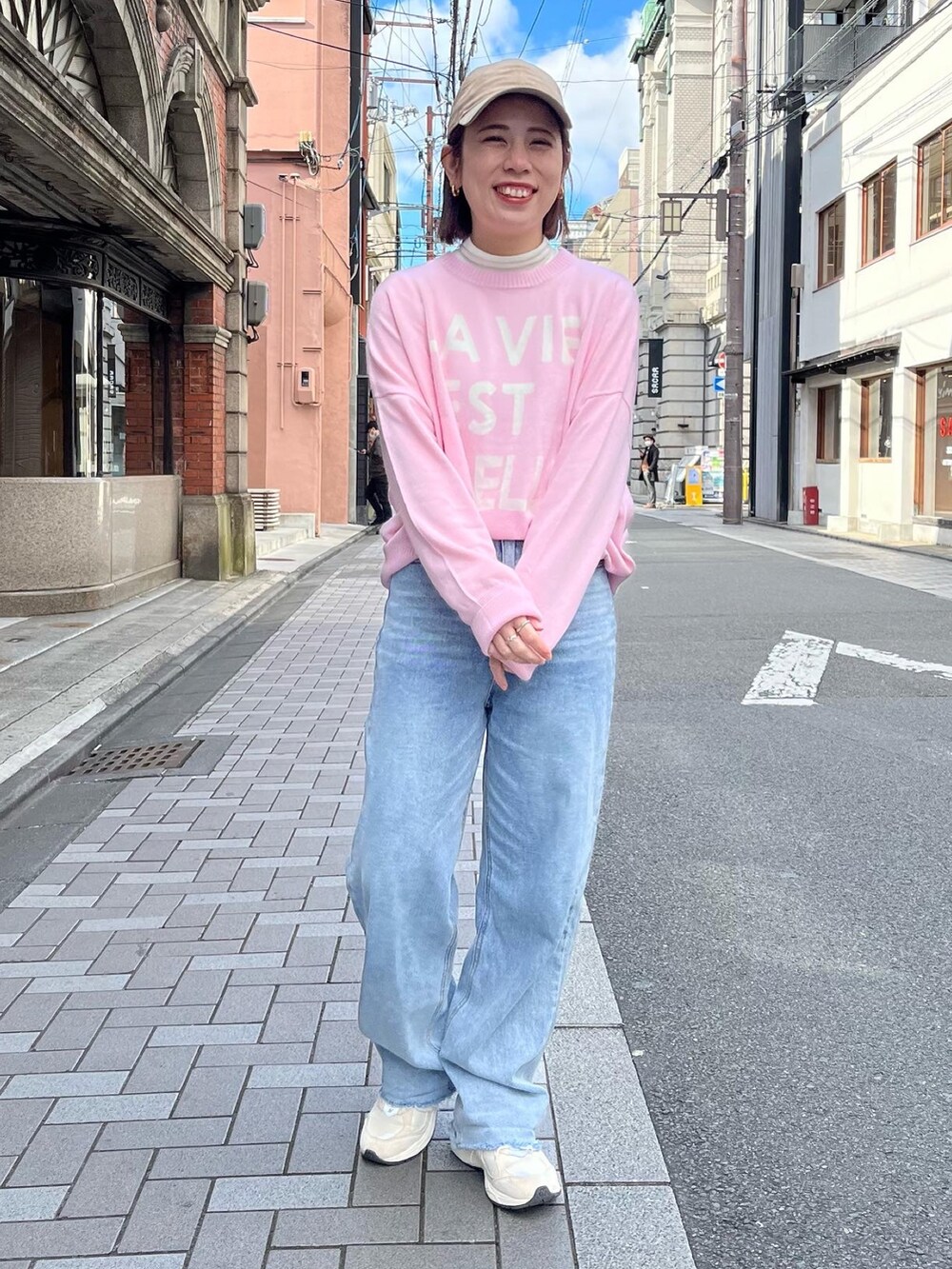 ピンク系のニット/セーター、ブルー系のデニムパンツを着用したレディースの冬コーディネートの2枚目の写真