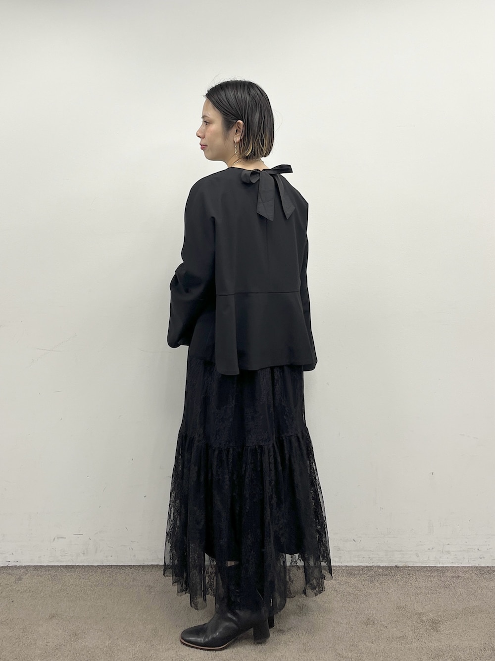 ブラック系のノーカラージャケット、ブラック系のハンドバッグ、ブラック系のワンピース/ドレスを着用したレディースの冬コーディネートの2枚目の写真