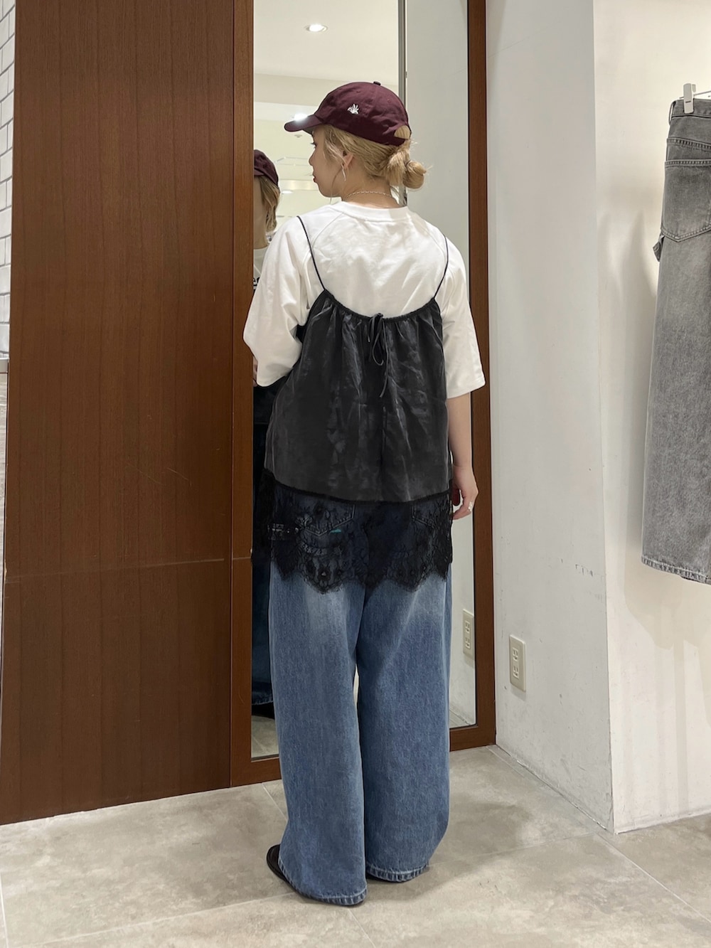 ブラック系のキャミソール、ホワイト系のTシャツ/カットソー、ブルー系のデニムパンツを着用したレディースの春コーディネートの2枚目の写真