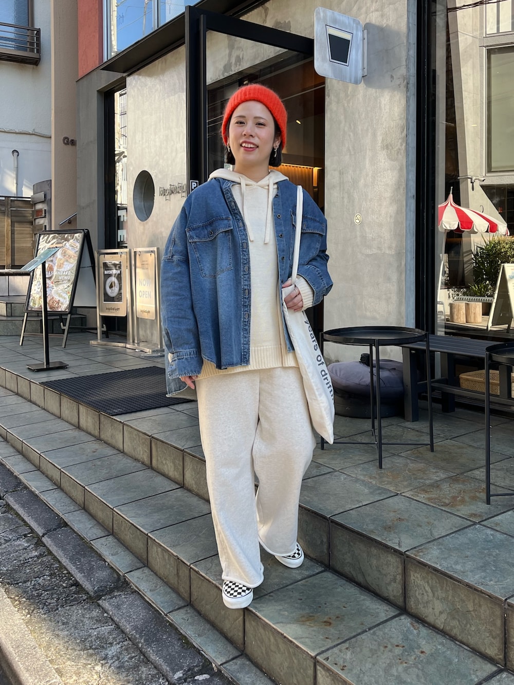 ホワイト系のニット/セーター、ブルー系のシャツ/ブラウス、ベージュ系のスウェットパンツを着用したレディースの秋コーディネートの2枚目の写真