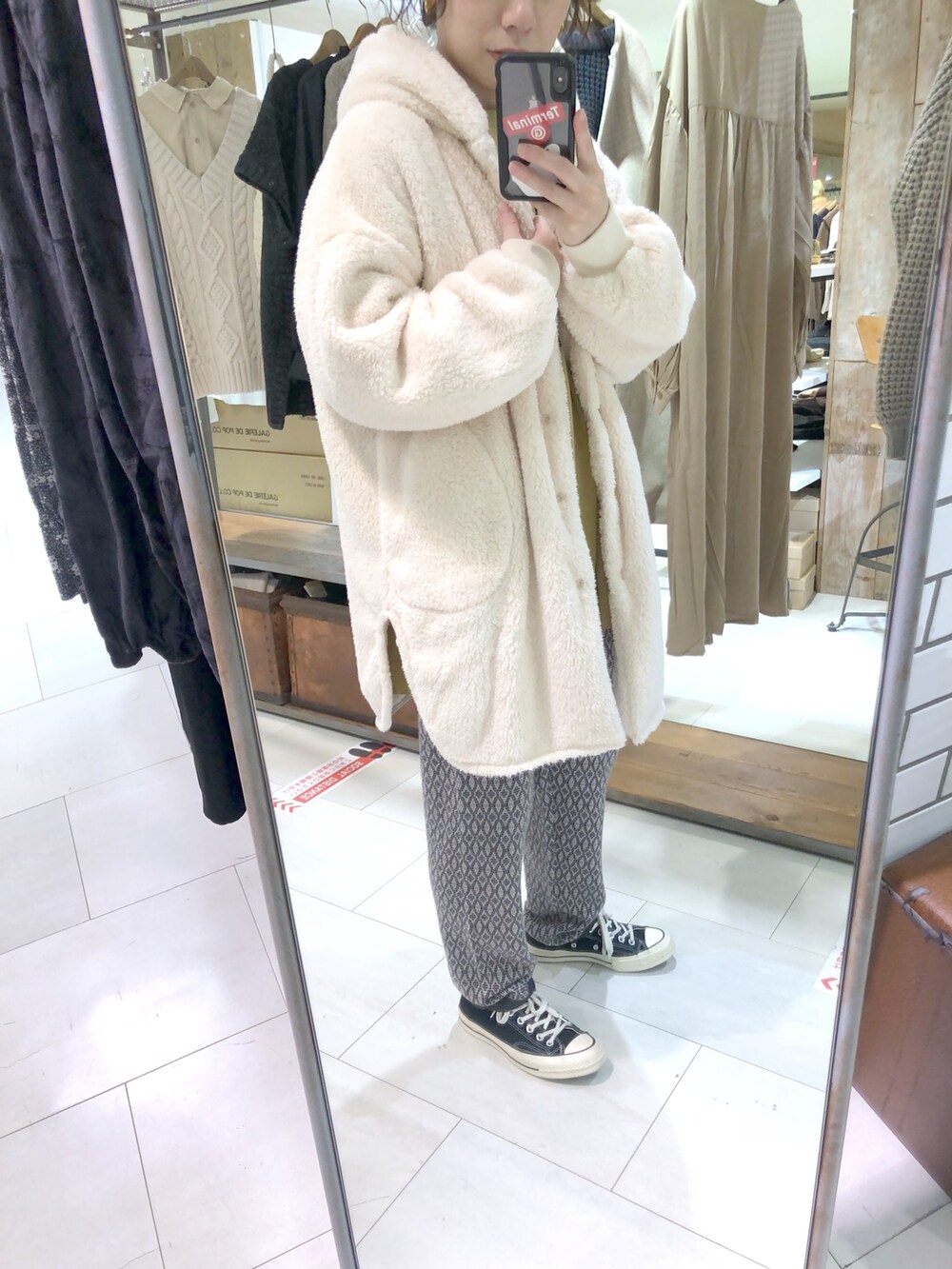 ホワイト系のその他アウター、イエロー系のTシャツ/カットソー、ブラック系のその他パンツを着用したレディースの冬コーディネートの2枚目の写真