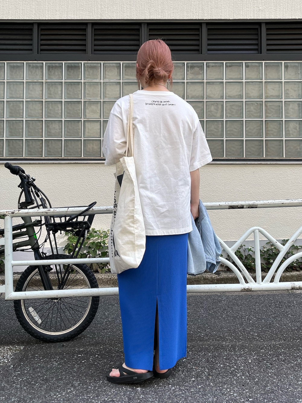 ブルー系のスカート、ブラック系のサンダル、ホワイト系のTシャツ/カットソーを着用したレディースの夏コーディネートの3枚目の写真