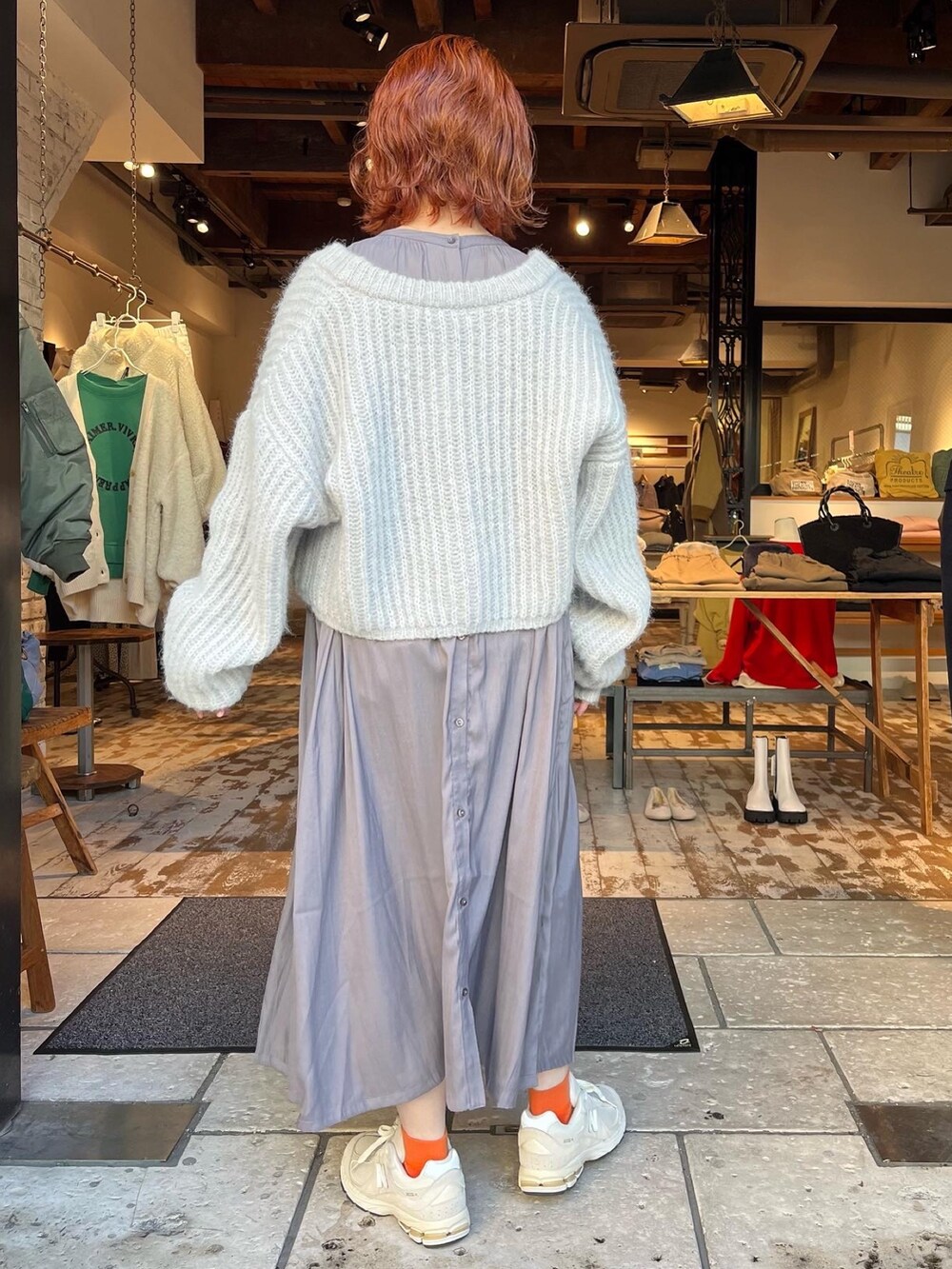 グレー系のカーディガン/ボレロ、グレー系のワンピース、ホワイト系のスニーカーを着用したレディースの秋コーディネートの2枚目の写真