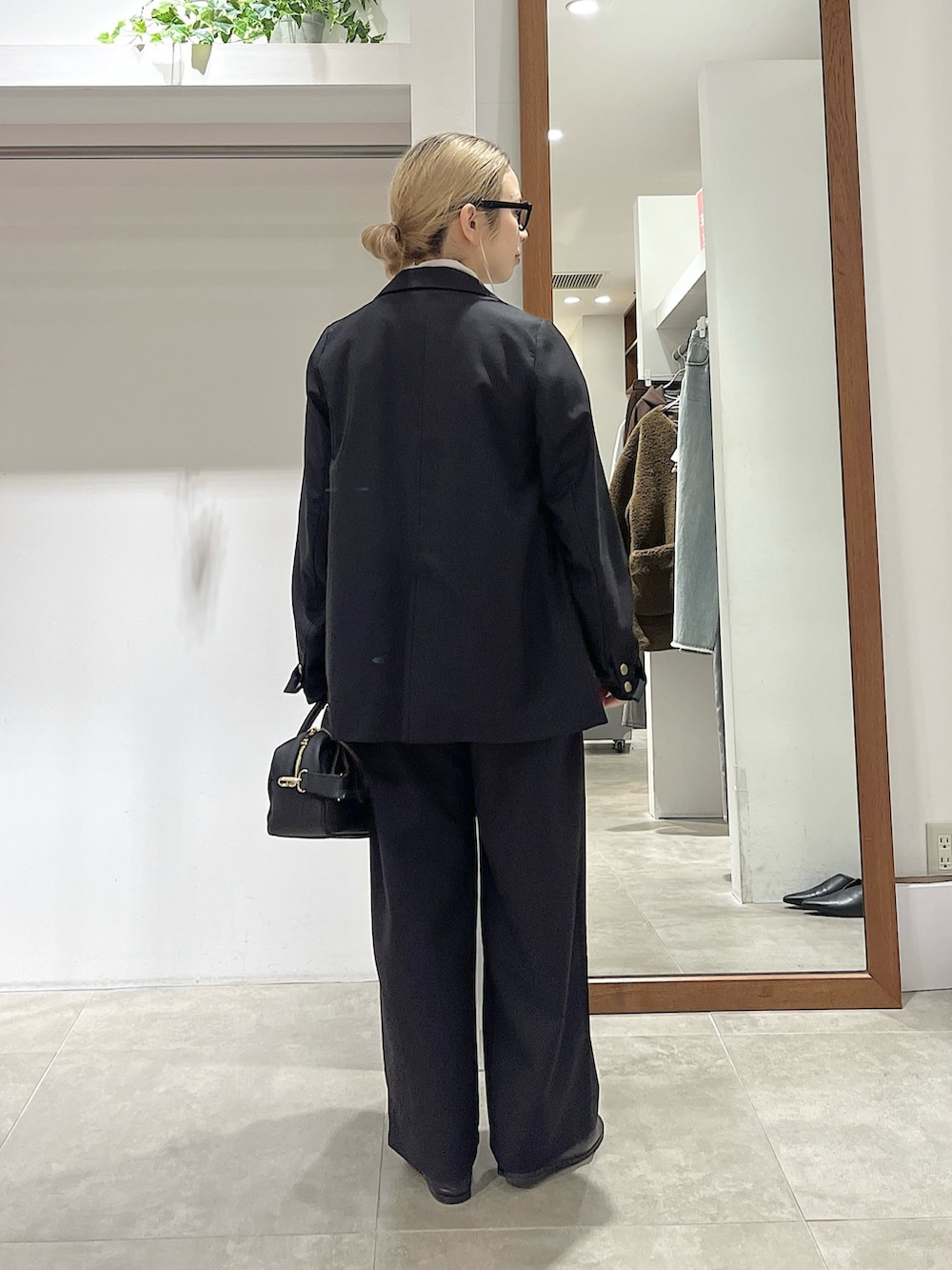 ブラック系のテーラードジャケット、ホワイト系のシャツ/ブラウス、ブラック系のトートバッグを着用したレディースの冬コーディネートの2枚目の写真