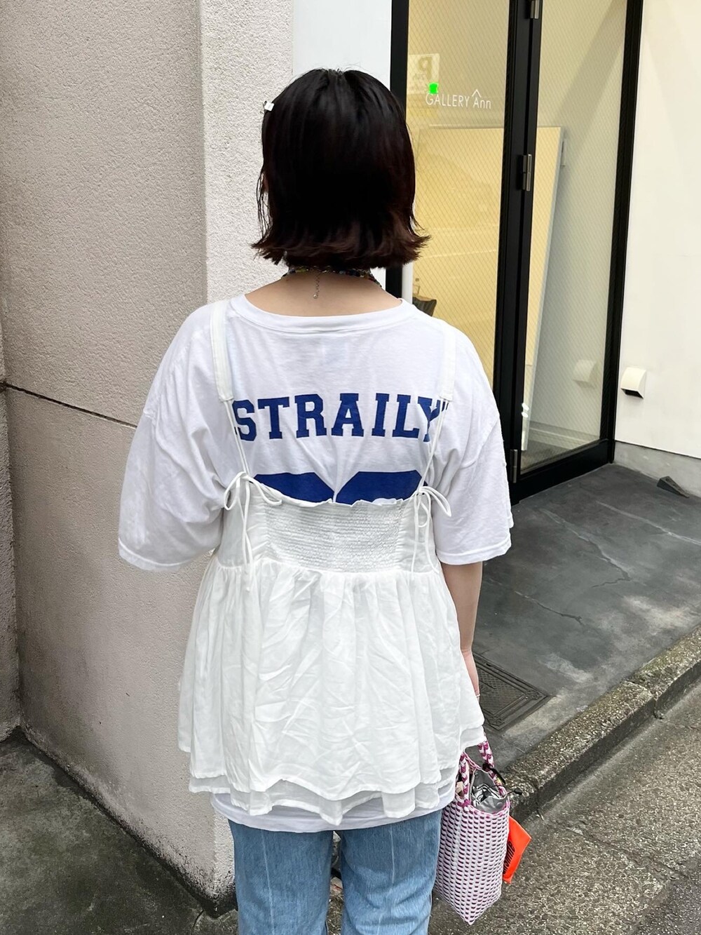 ホワイト系のキャミソール、ピンク系のかごバッグ、ブラック系のサンダルを着用したレディースの夏コーディネートの3枚目の写真