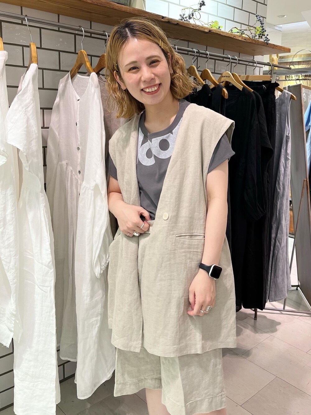 グレー系のTシャツ/カットソー、ベージュ系のダウンベスト、ベージュ系のその他パンツを着用したレディースの夏コーディネートの3枚目の写真