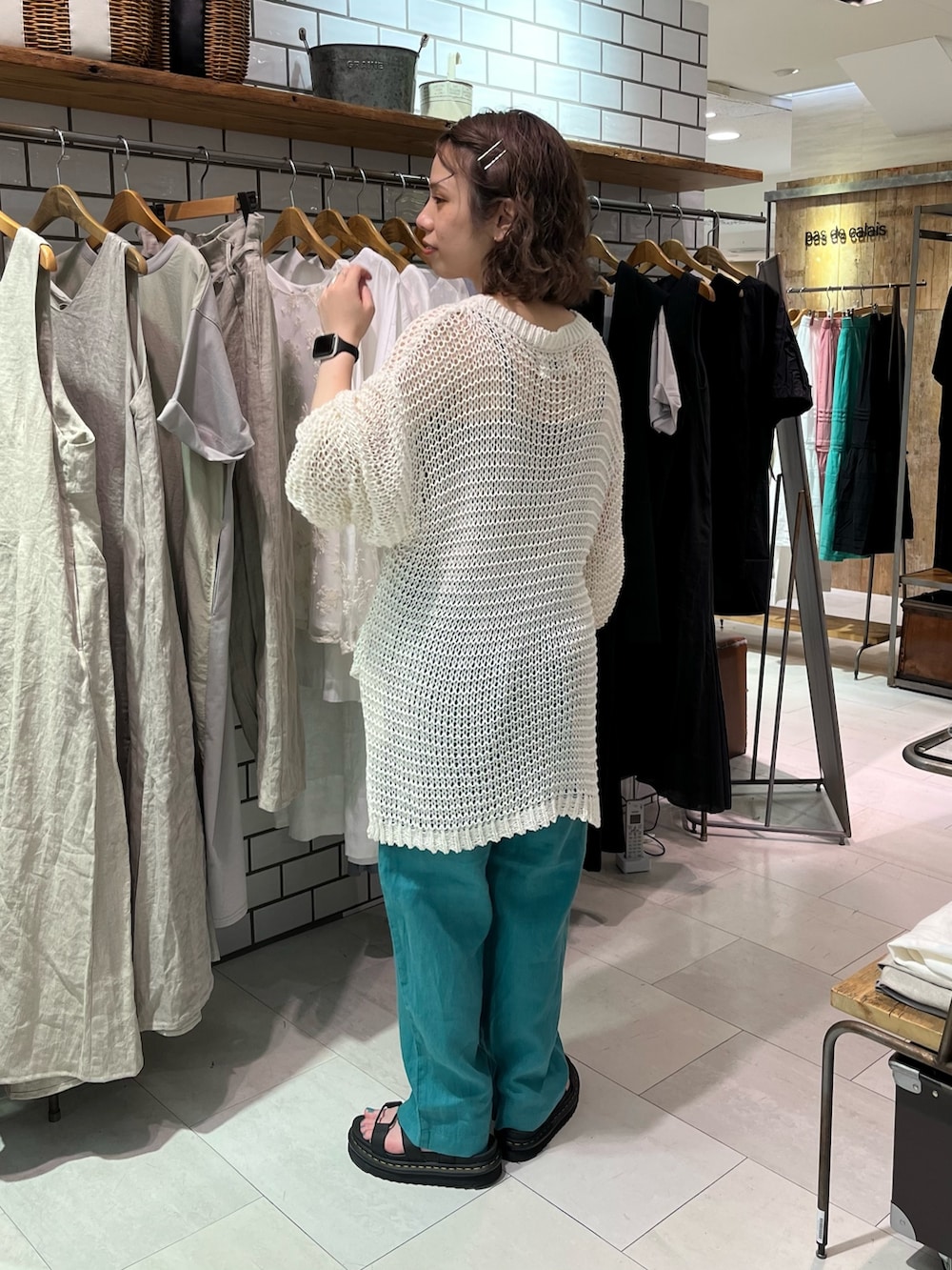 ホワイト系のニット/セーター、グリーン系のその他パンツ、ブラック系のサンダルを着用したレディースの夏コーディネートの3枚目の写真