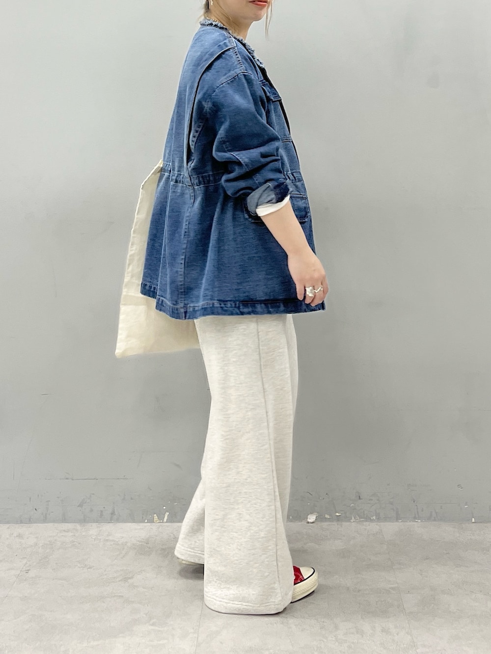 ブルー系のデニムジャケット、ホワイト系のTシャツ/カットソー、ベージュ系のスウェットパンツを着用したレディースの秋コーディネートの2枚目の写真