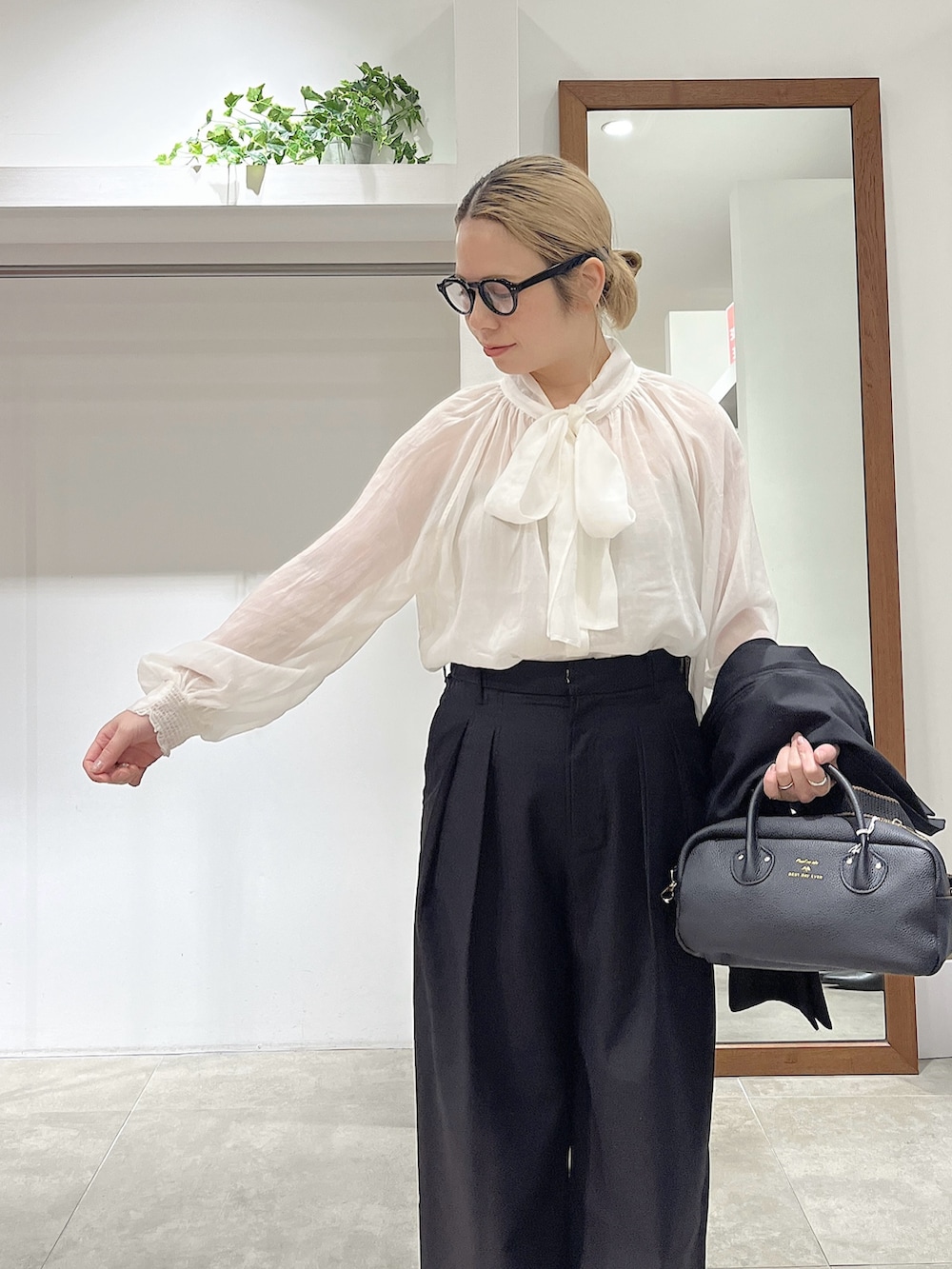 ブラック系のテーラードジャケット、ホワイト系のシャツ/ブラウス、ブラック系のトートバッグを着用したレディースの冬コーディネートの3枚目の写真