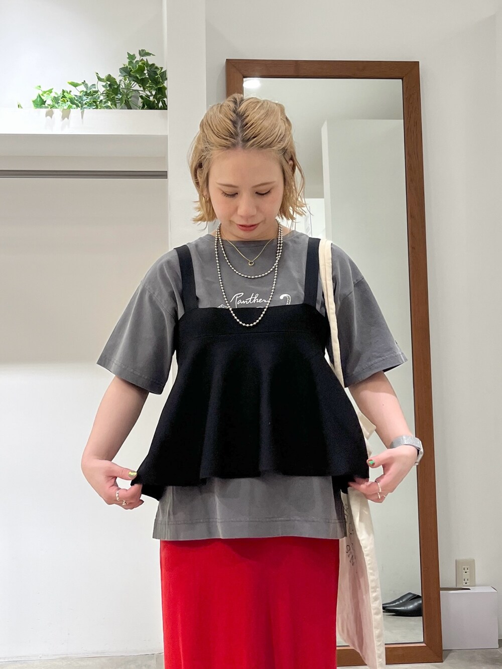 ブラック系のベスト、グレー系のTシャツ/カットソー、レッド系のスカートを着用したレディースの春コーディネートの2枚目の写真