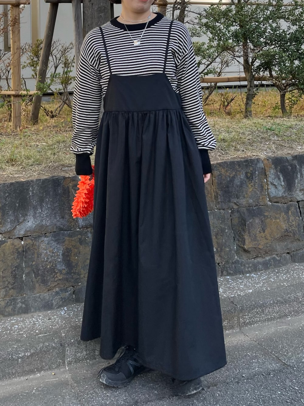 ブラック系のワンピース、ベージュ系のカーディガン/ボレロを着用したレディースの冬コーディネートの2枚目の写真