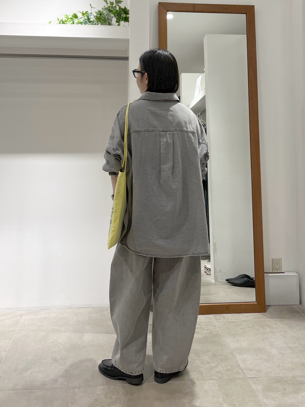 グレー系のシャツ/ブラウス、グレー系のデニムパンツ、ブラック系のローファーを着用したレディースの春コーディネートの2枚目の写真