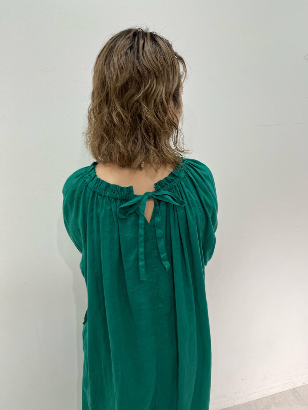 グリーン系のワンピース、ブラック系のサンダルを着用したレディースの夏コーディネートの3枚目の写真