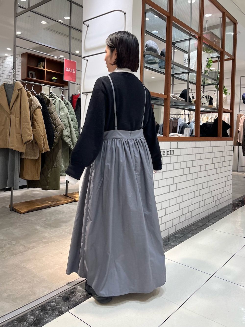 グレー系のワンピース、ホワイト系のTシャツ/カットソーを着用したレディースの冬コーディネートの2枚目の写真