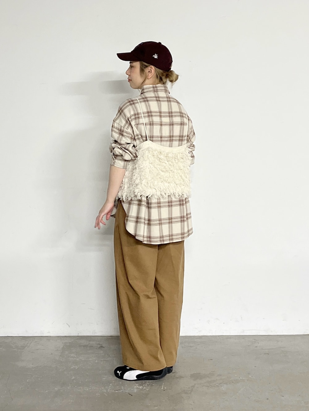 ホワイト系のニット/セーター、ベージュ系のシャツ/ブラウス、イエロー系のスラックスを着用したレディースの冬コーディネートの2枚目の写真