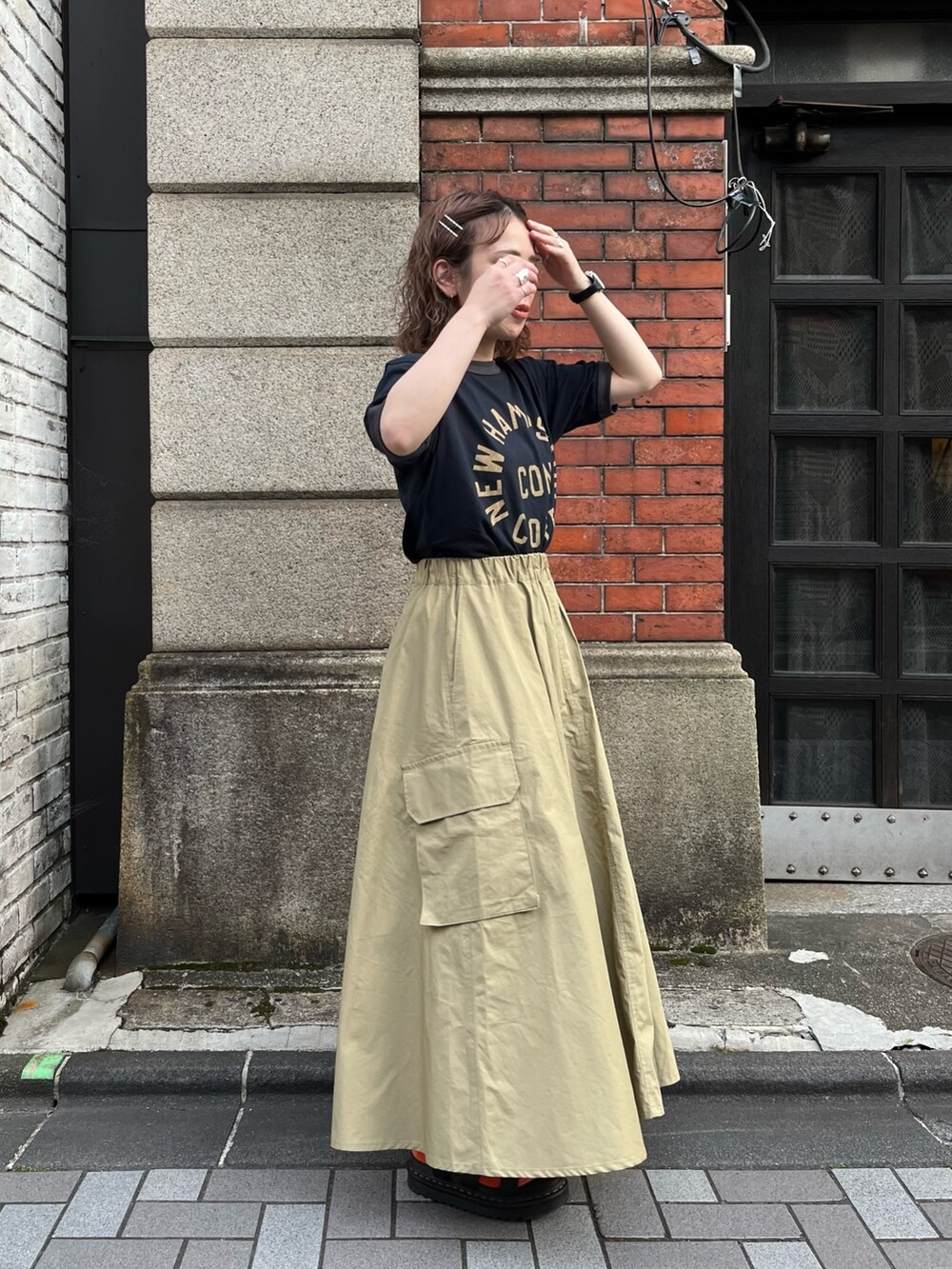 グリーン系のスカート、ブルー系のTシャツ/カットソー、ブラック系のサンダルを着用したレディースの夏コーディネートの3枚目の写真