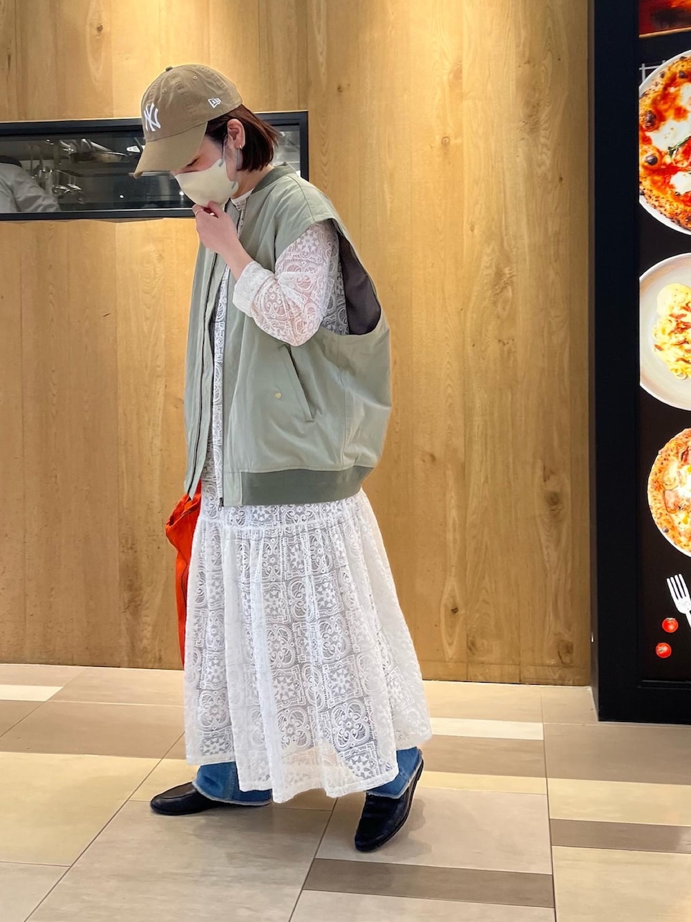 グリーン系のMA-1、ホワイト系のワンピース、オレンジ系のエコバッグ/サブバッグを着用したレディースの冬コーディネートの2枚目の写真