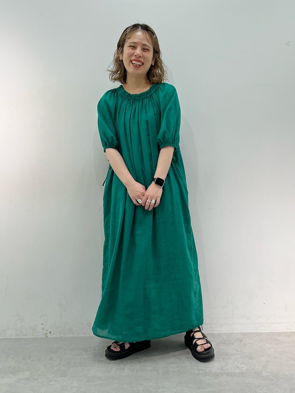 グリーン系のワンピース、ブラック系のサンダルを着用したレディースの夏コーディネートの2枚目の写真