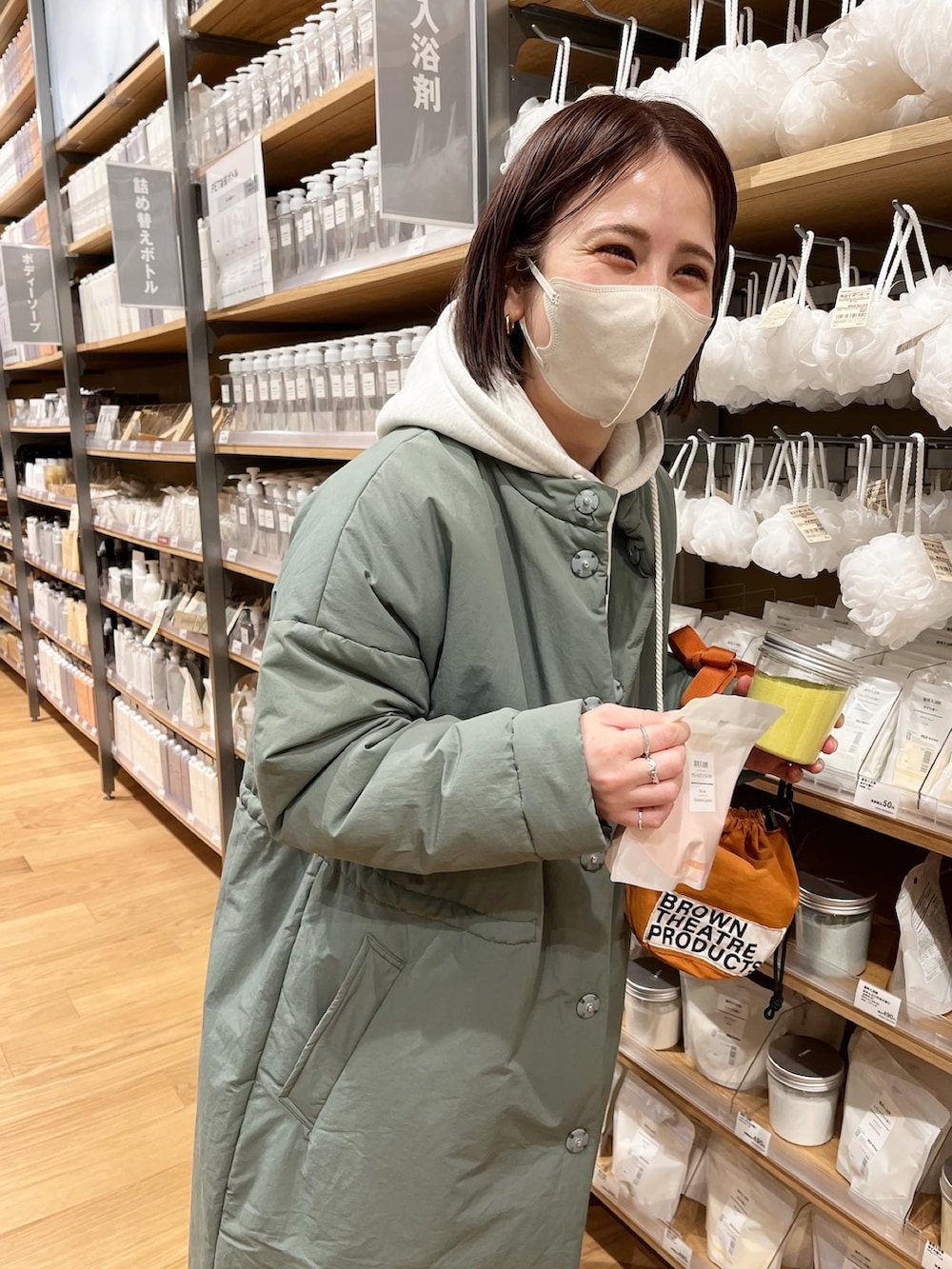 グリーン系のダウンジャケット/コート、ブルー系のデニムパンツ、グレー系のパーカーを着用したレディースの冬コーディネートの2枚目の写真