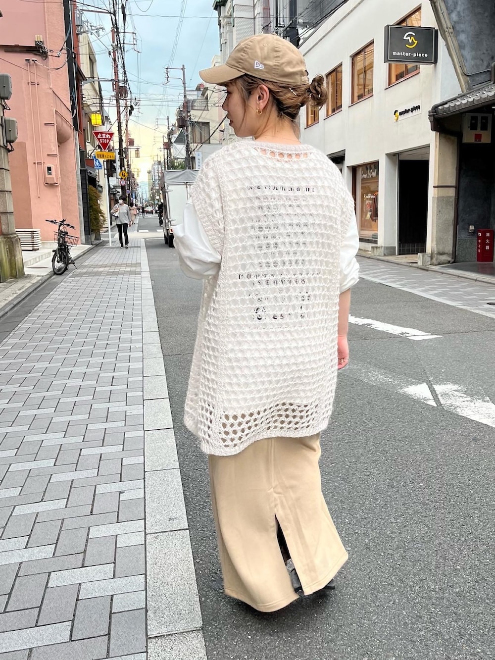 ホワイト系のニット/セーター、ホワイト系のTシャツ/カットソー、ベージュ系のスカートを着用したレディースの秋コーディネートの2枚目の写真