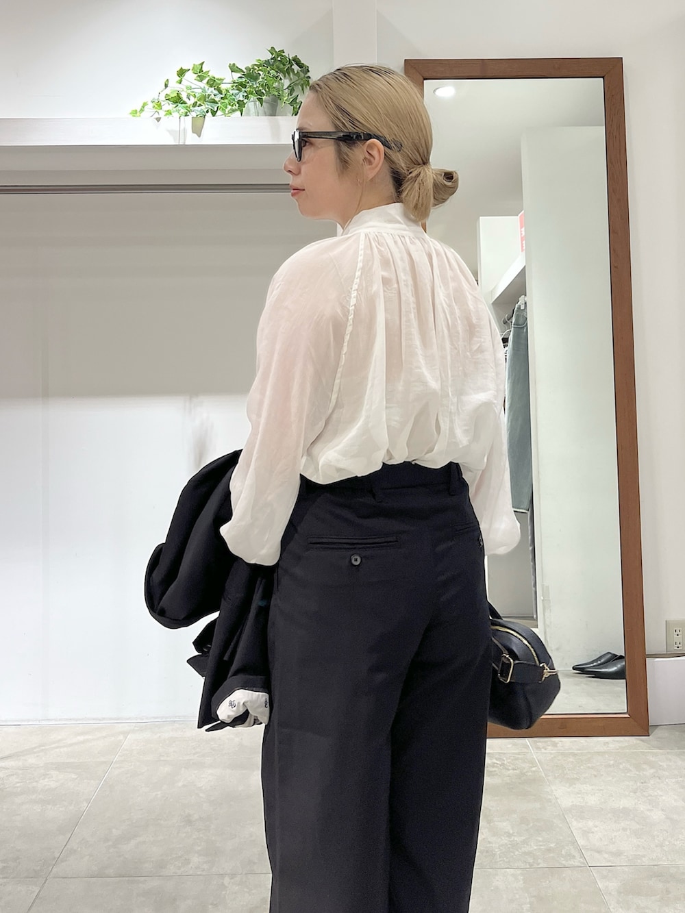 ブラック系のテーラードジャケット、ホワイト系のシャツ/ブラウス、ブラック系のトートバッグを着用したレディースの冬コーディネートの4枚目の写真