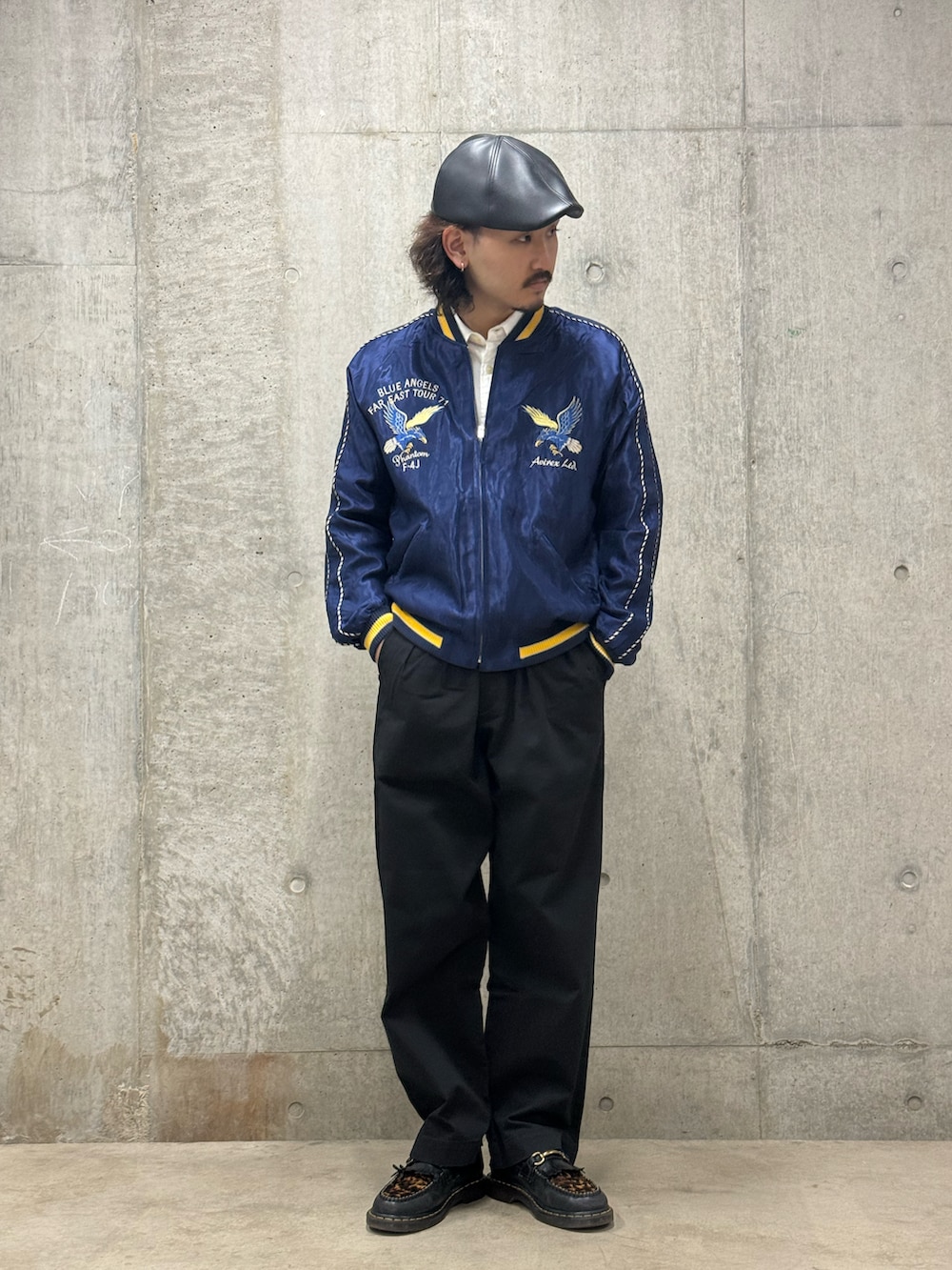 ブルー系のスカジャン、ブラック系のチノパンツを着用したメンズの春コーディネートの2枚目の写真