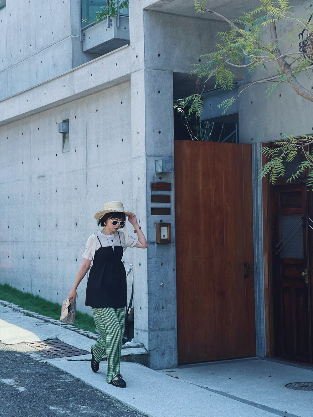 ブラック系のキャミソール、ベージュ系のトートバッグ、グリーン系のその他パンツを着用したレディースの夏コーディネートの4枚目の写真