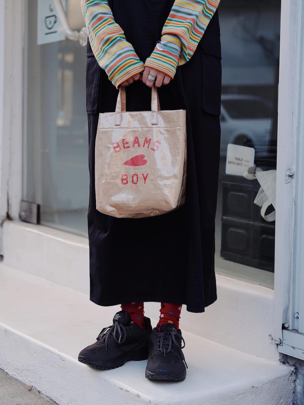 イエロー系のTシャツ/カットソー、ベージュ系のトートバッグ、ブルー系のワンピースを着用したレディースの冬コーディネートの2枚目の写真