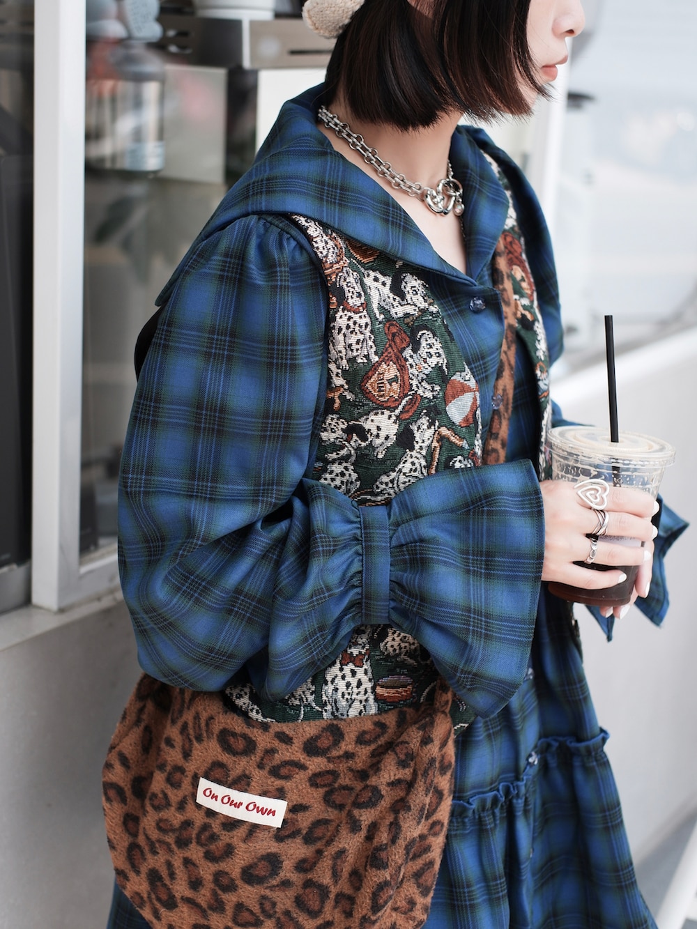 ホワイト系のスカート、ブラック系のスニーカーを着用したレディースの春コーディネートの2枚目の写真