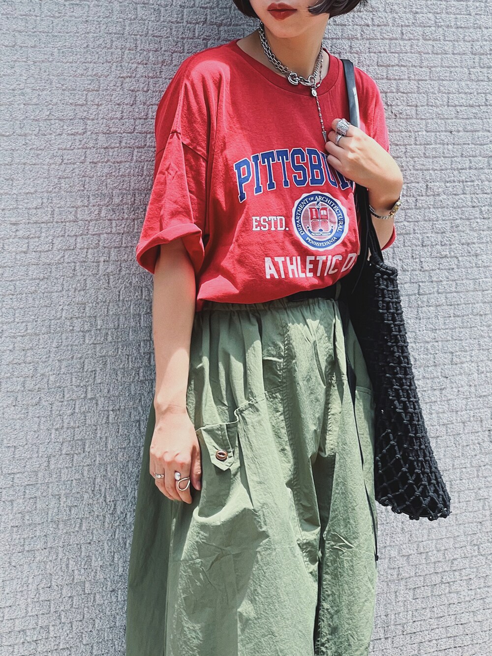 レッド系のTシャツ/カットソー、ブラック系のサンダルを着用したレディースの夏コーディネートの3枚目の写真