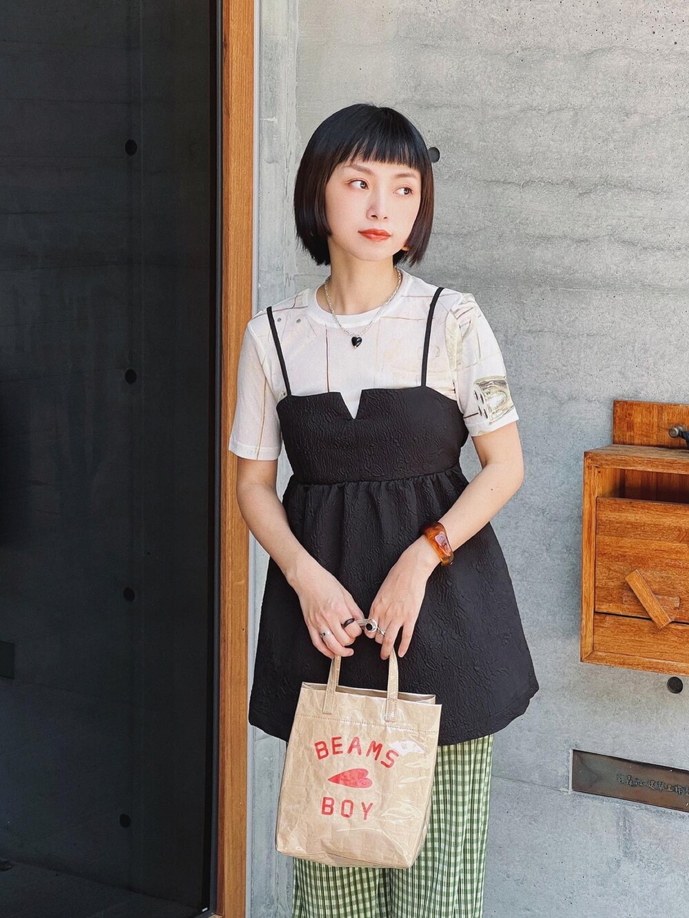 ブラック系のキャミソール、ベージュ系のトートバッグ、グリーン系のその他パンツを着用したレディースの夏コーディネートの3枚目の写真