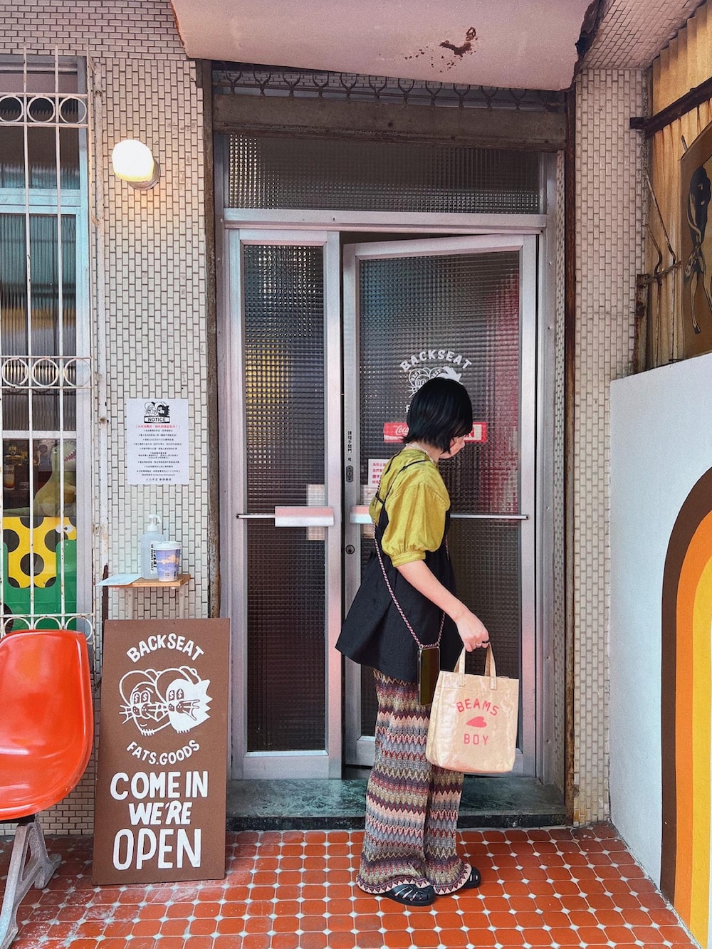 ベージュ系のトートバッグ、ベージュ系のキャミソール、グリーン系のトップスを着用したレディースの秋コーディネートの3枚目の写真