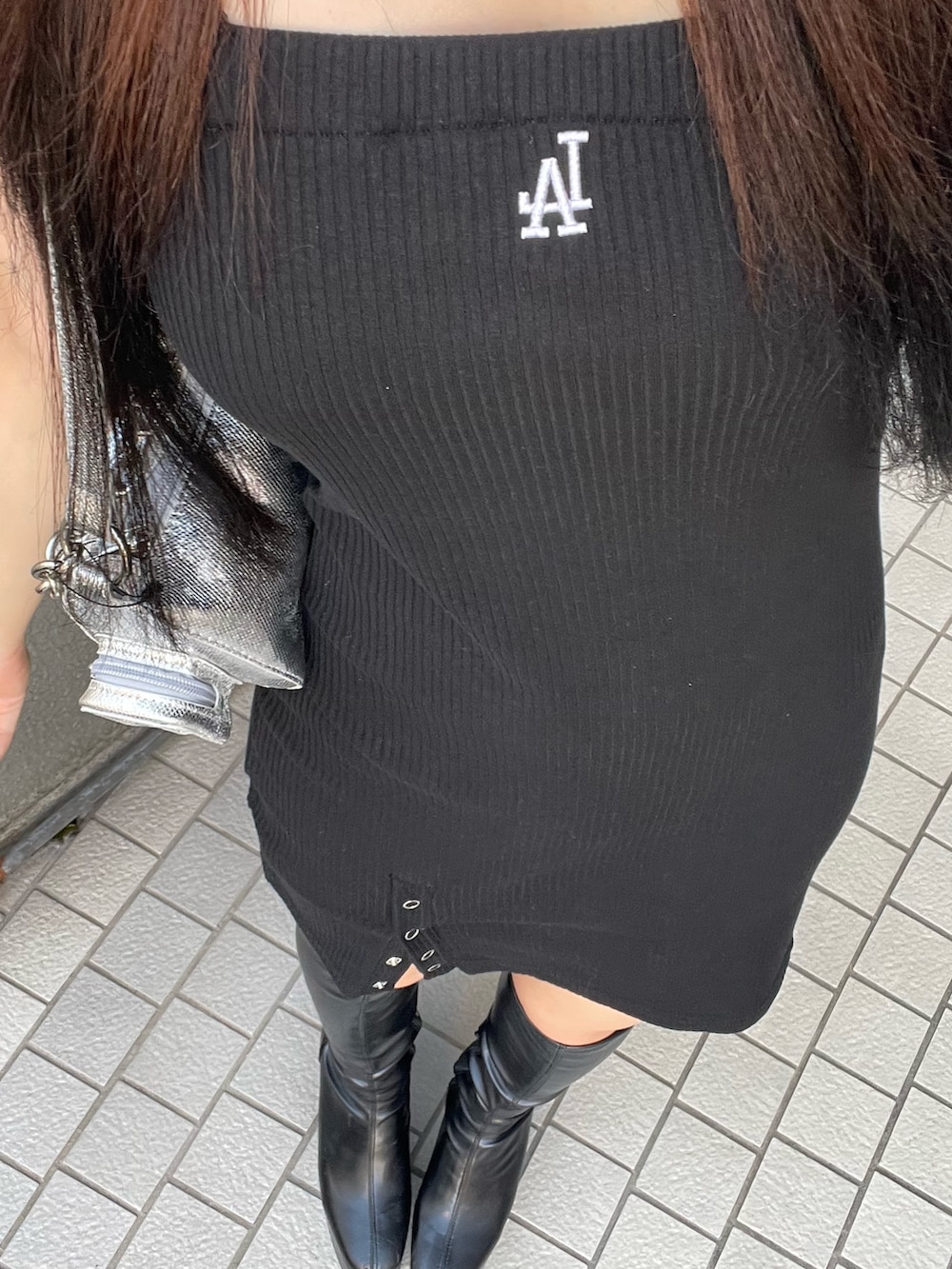 ブラック系のワンピース、シルバー系のショルダーバッグを着用したレディースの夏コーディネートの2枚目の写真