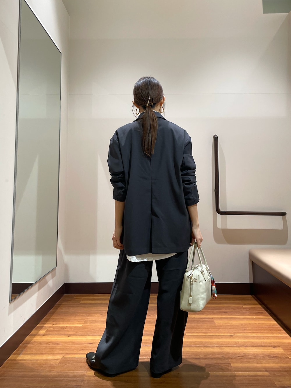 ブラック系のローファー、ホワイト系のボストンバッグ、グレー系のその他パンツを着用したレディースの春コーディネートの2枚目の写真