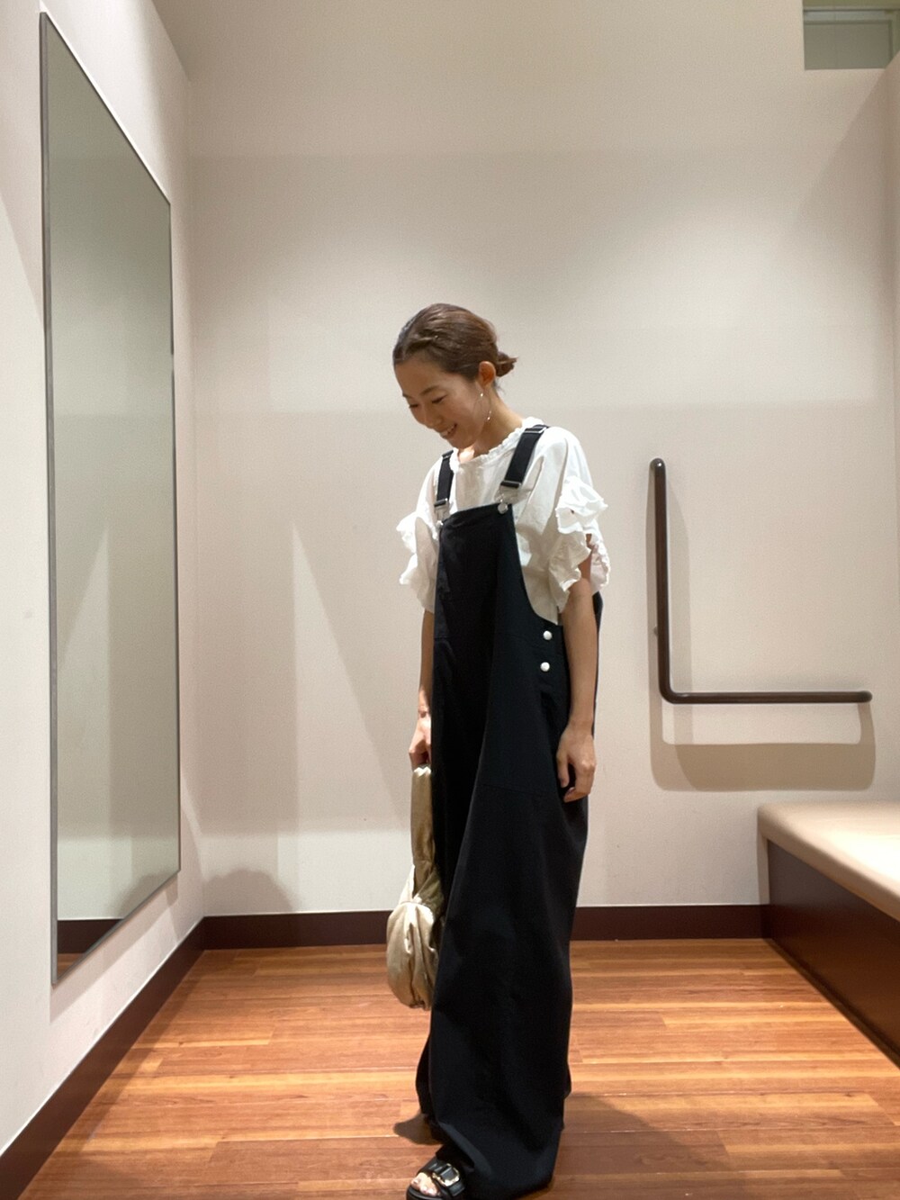 ブラック系のサロペット/オーバーオール、ホワイト系のシャツ/ブラウス、ブラック系のサンダルを着用したレディースの夏コーディネートの2枚目の写真