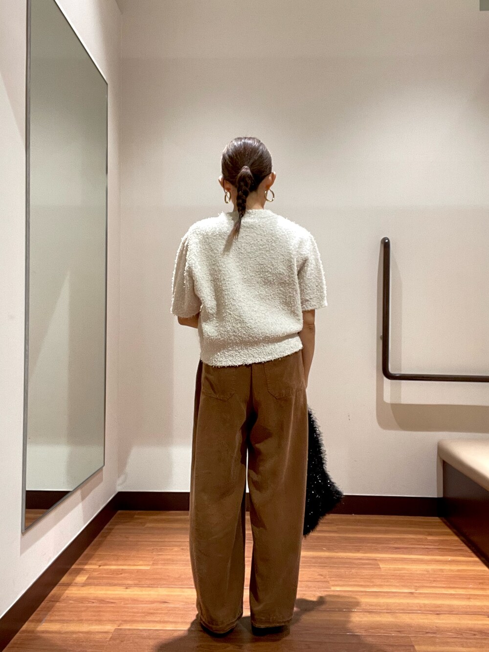 ホワイト系のニット/セーター、ブラウン系のその他パンツ、ブラック系のトートバッグを着用したレディースの秋コーディネートの4枚目の写真