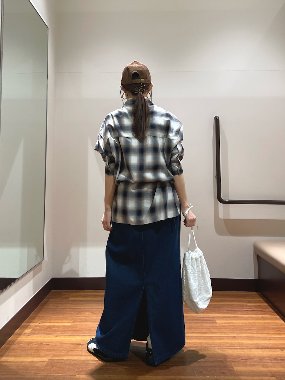 ブルー系のワンピース、ブラック系のスニーカー、ホワイト系のショルダーバッグを着用したレディースの春コーディネートの3枚目の写真