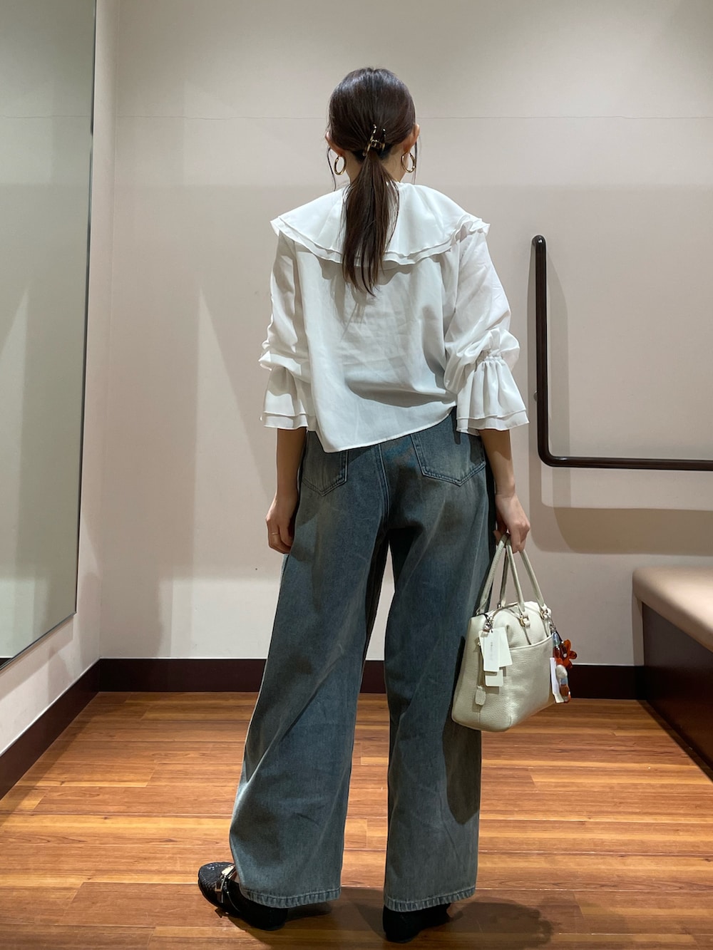 ブラック系のその他シューズ、ホワイト系のボストンバッグ、ブルー系のデニムパンツを着用したレディースの春コーディネートの2枚目の写真