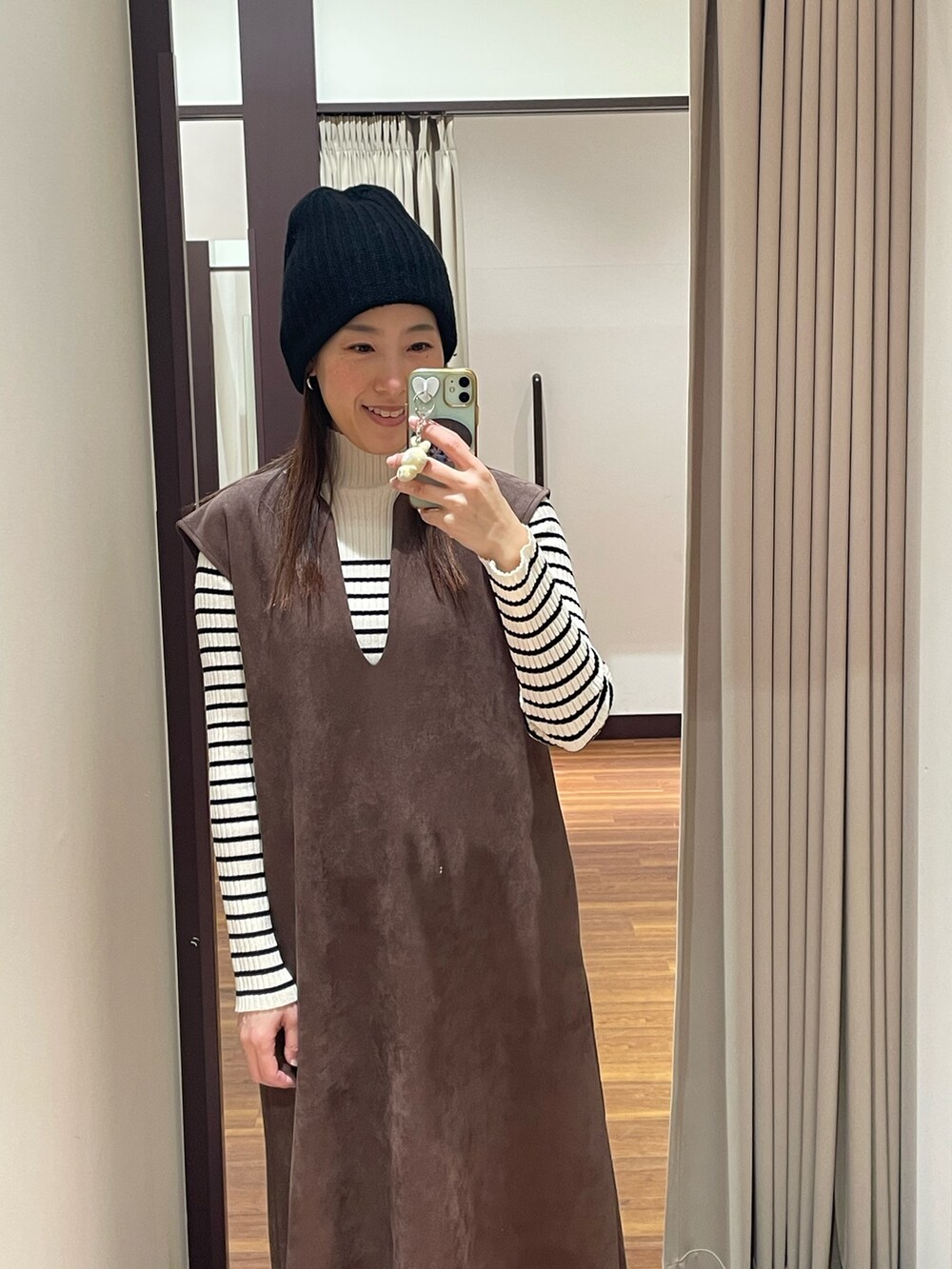 ブラウン系のワンピース、その他のニット/セーター、ブラック系のスニーカーを着用したレディースの冬コーディネートの5枚目の写真